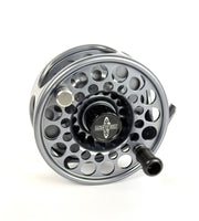 Silver fly fishing reel on a white background